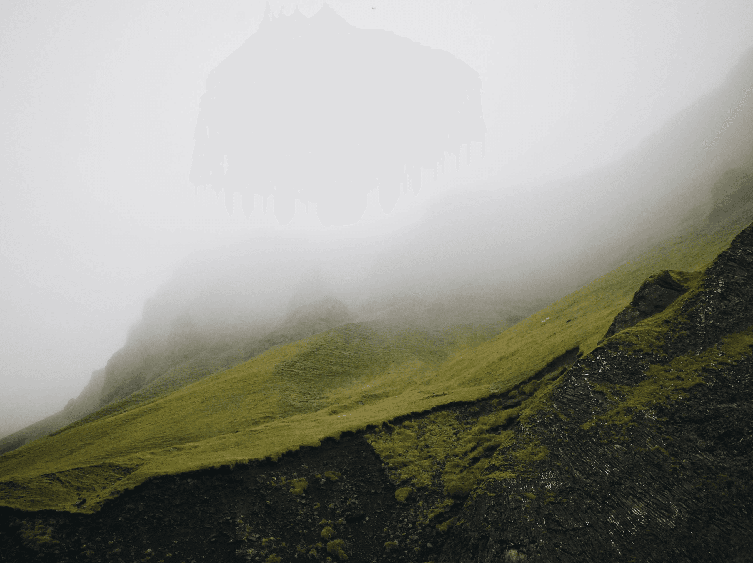 A green ridge running down into cloud